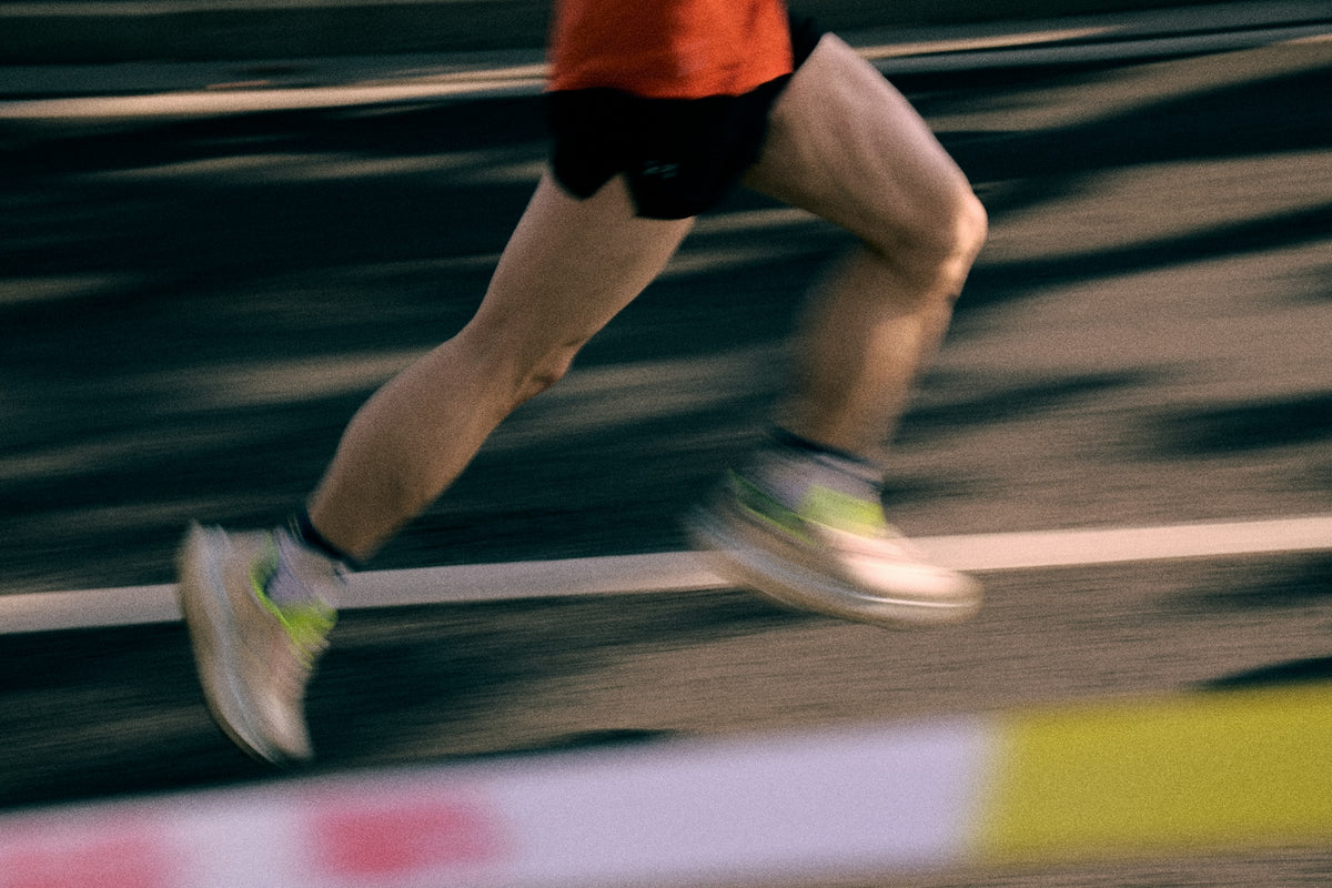 Jambes de coureur en pleine foulée sur une piste
